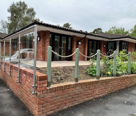 Corner of low wall with raised garden and buiding behind